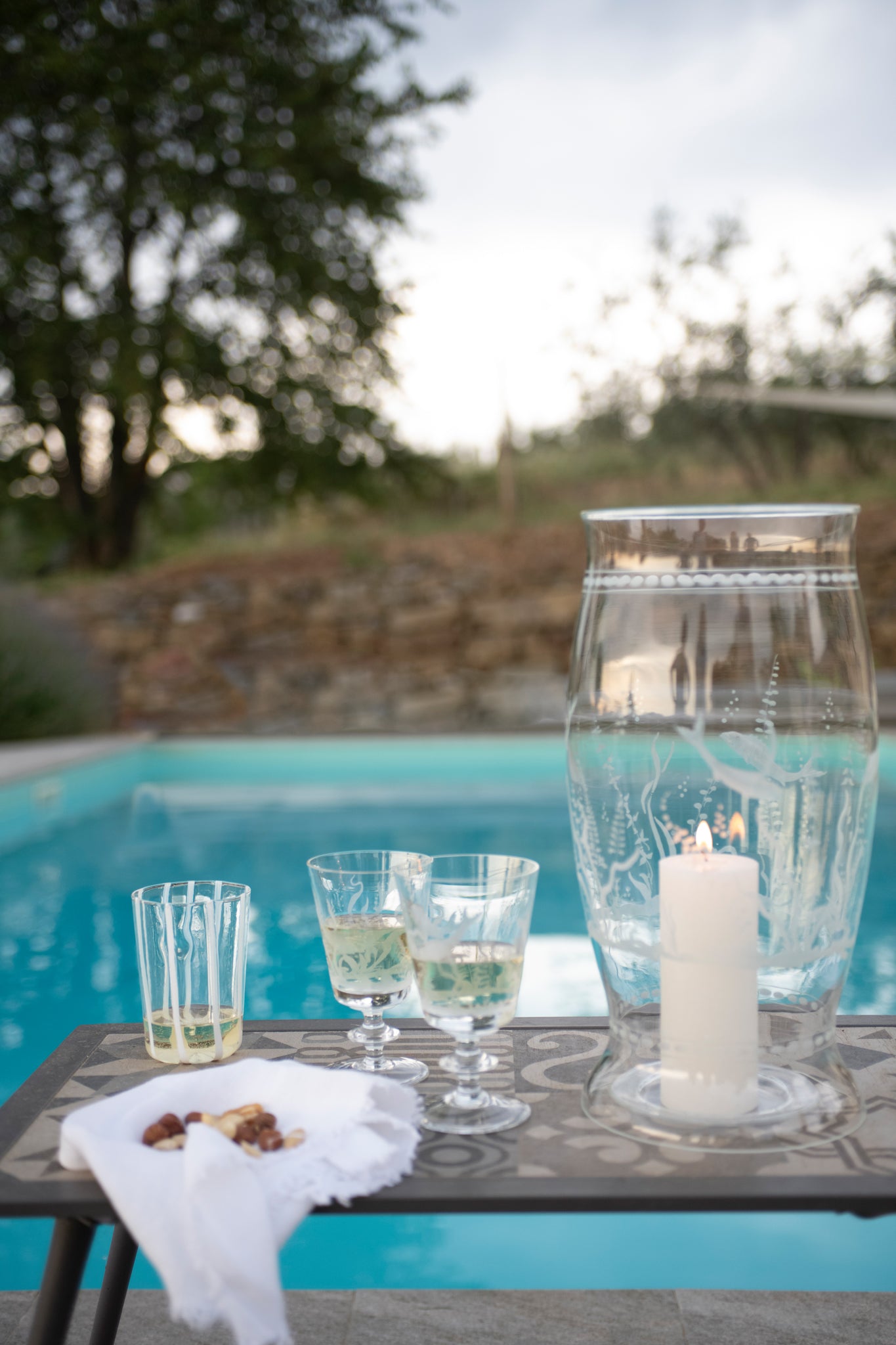 Tuscany-bythepool-hurricane-vase-glasses-wine-nuts